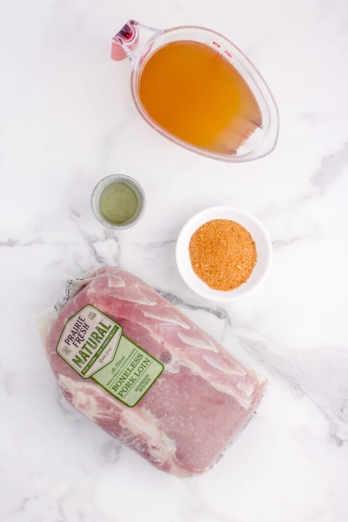 Ingredients to make Instant Pot pork loin: chicken broth, olive oil, pork seasoning, and a pork loin.