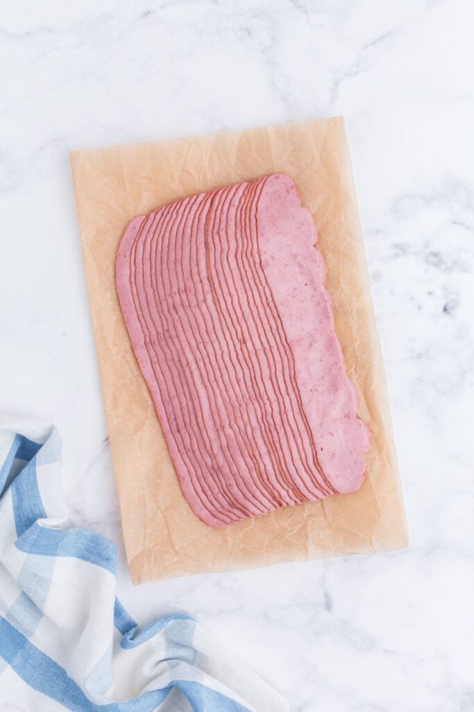 Raw turkey bacon on a sheet of parchment paper.