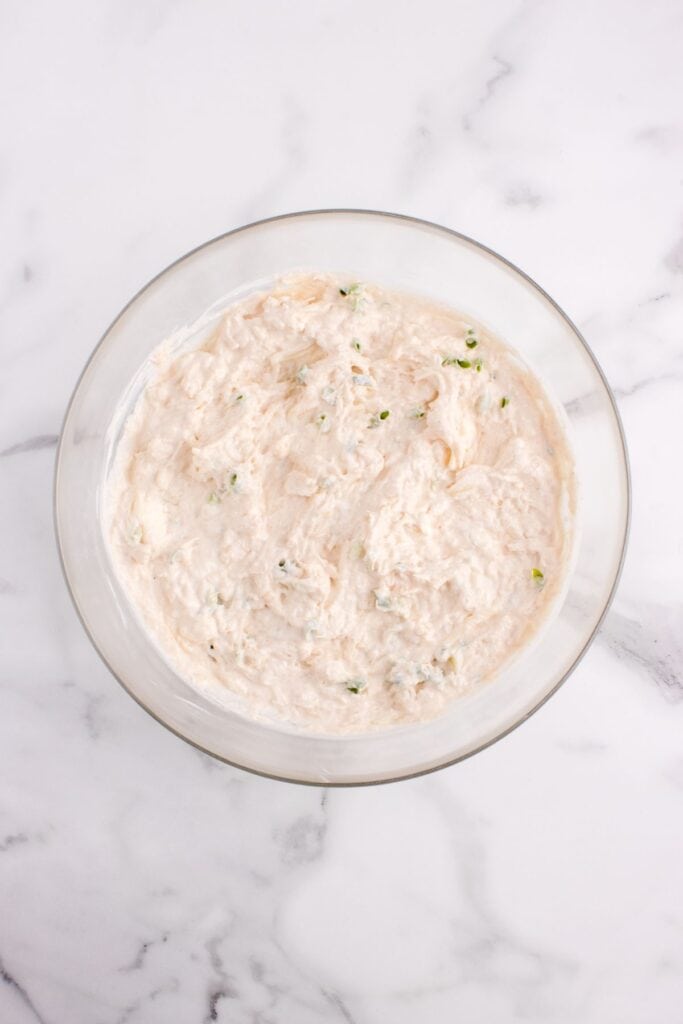 Crab rangoon dip before baking in a glass bowl.