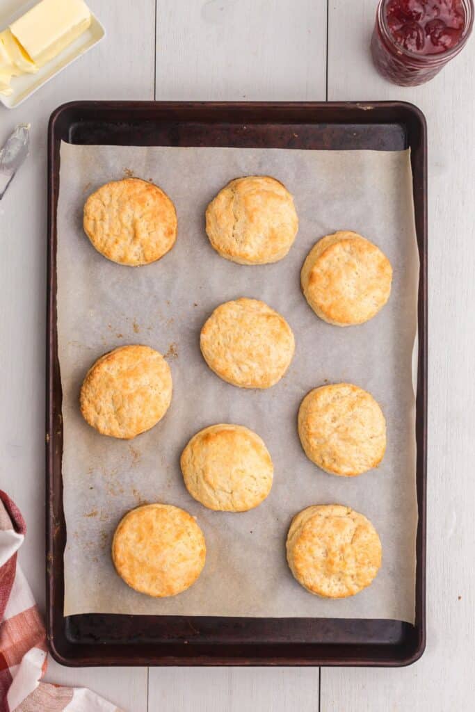 Baked biscuits on a baking sheet lined in parchment paper.