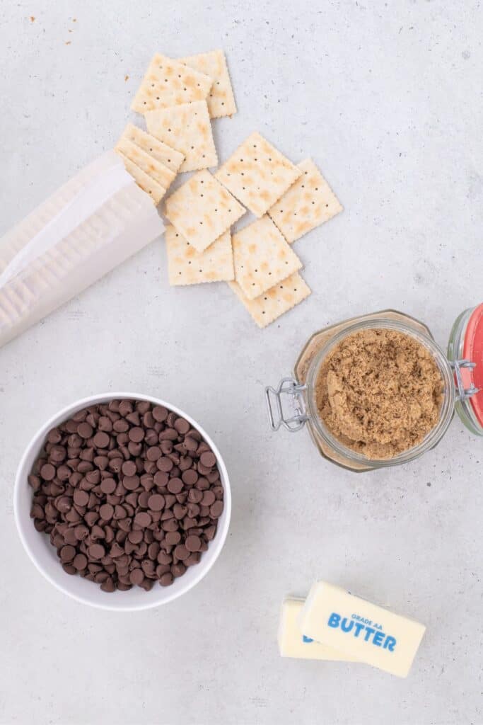 Ingredients for saltine cracker toffee: Saltine crackers, chocolate chips, brown sugar, and butter.