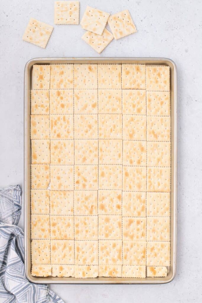 Saltines are lined on a baking sheet for saltine cracker toffee.