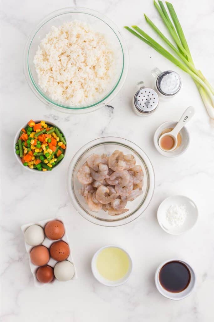 Ingredients for shrimp fried rice: shrimp, cornstarch, salt, black pepper, canola oil, eggs, leftover rice, frozen mixed vegetables, soy sauce, sesame oil, green onions