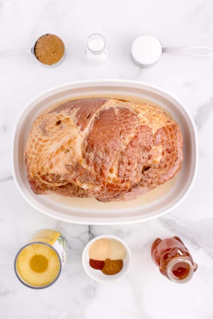 Ingredients for a spiral sliced ham: Spiral ham, pineapple juice, brown sugar, sugar, honey, salt, cinnamon, paprika, onion powder, and garlic powder.