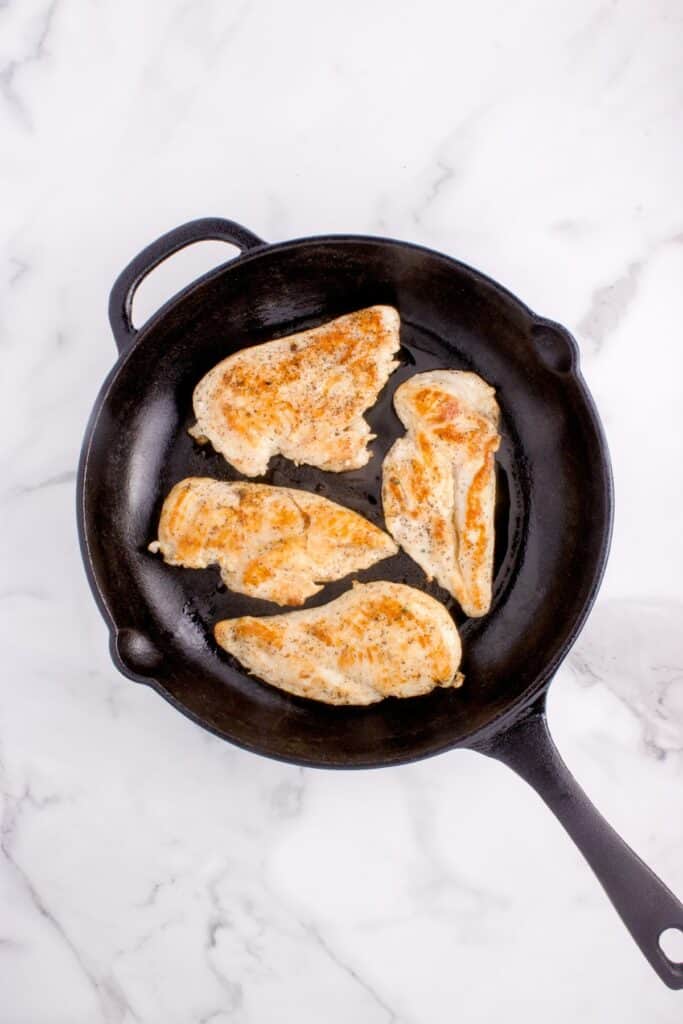 Chicken breast cooked in a cast iron skillet.