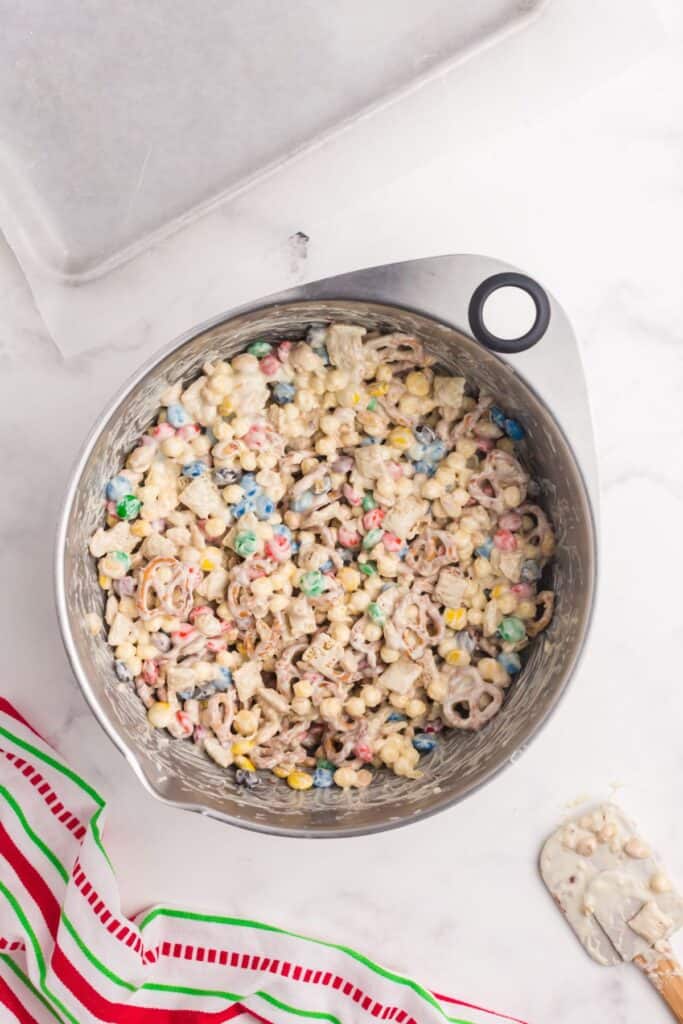 White trash candy (white chocolate chex mix candy) in a mixing bowl.