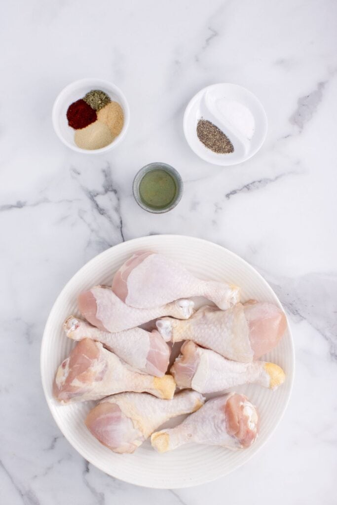 Ingredients for baked chicken legs: chicken drumsticks, salt, black pepper, onion powder, garlic powder, smoked paprika, Italian seasoning, and olive oil