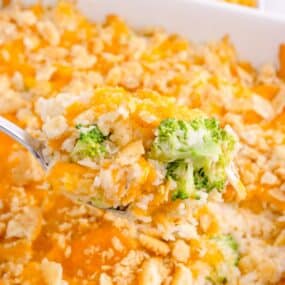 Baking dish with the completed casserole. A serving spoon is lifting a scoop of casserole out of the dish.