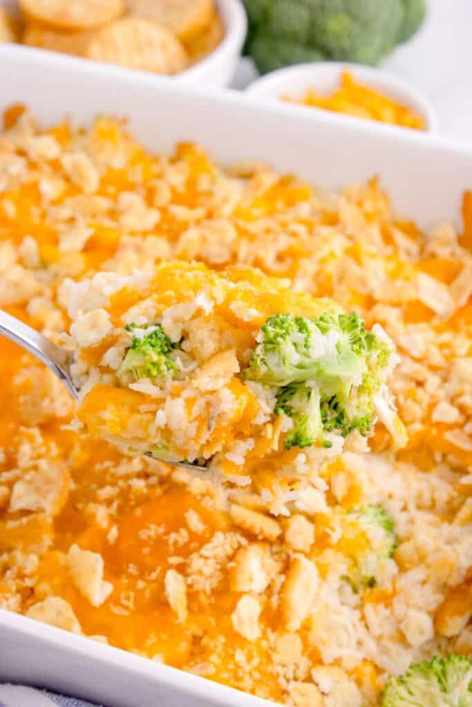 Baking dish with the completed casserole. A serving spoon is lifting a scoop of casserole out of the dish.