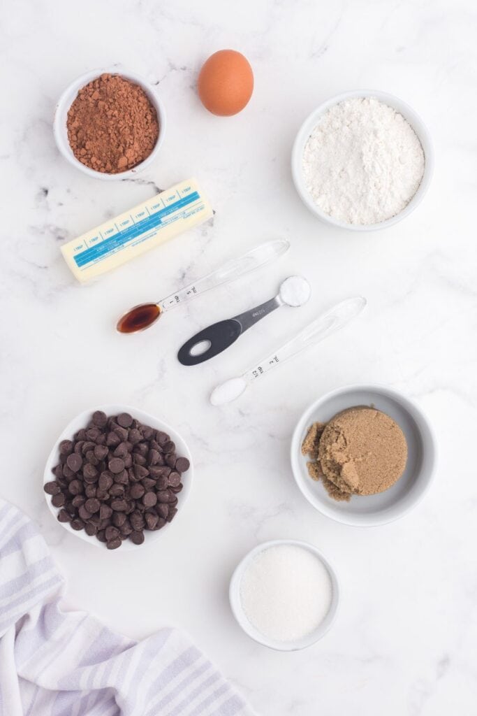 Ingredients for double chocolate chip cookies: unsalted butter, dark brown sugar, granulated sugar, vanilla extract, egg, all-purpose flour, cocoa powder, baking soda, salt, chocolate chips