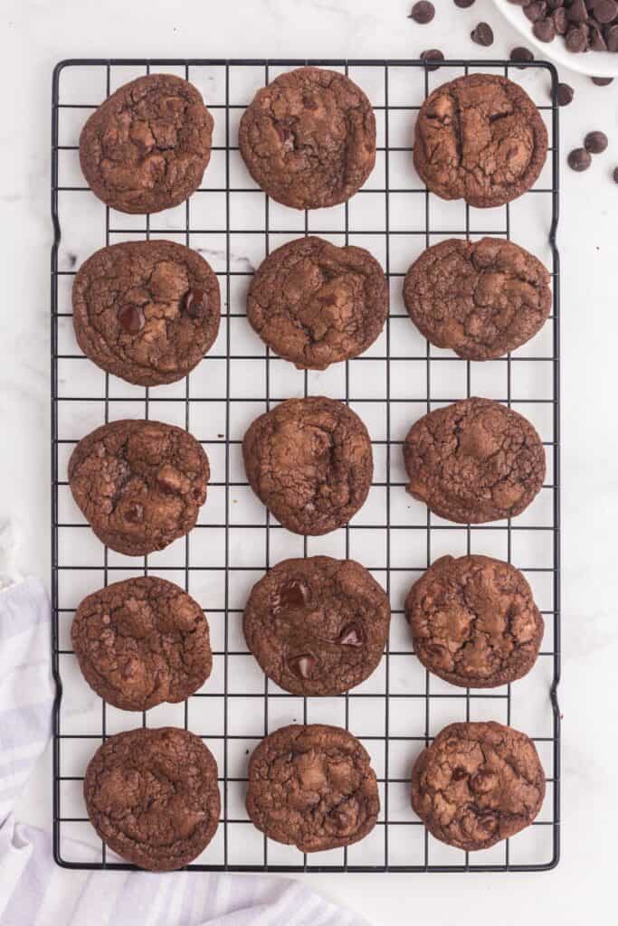 Cooling rack with double chocolate chip cookies on it.