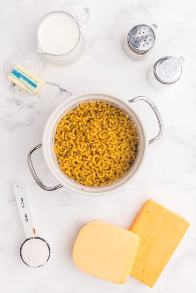 Ingredients for gouda mac and cheese: macaroni, butter, flour, whole milk, gouda, sharp cheddar, salt, and pepper.