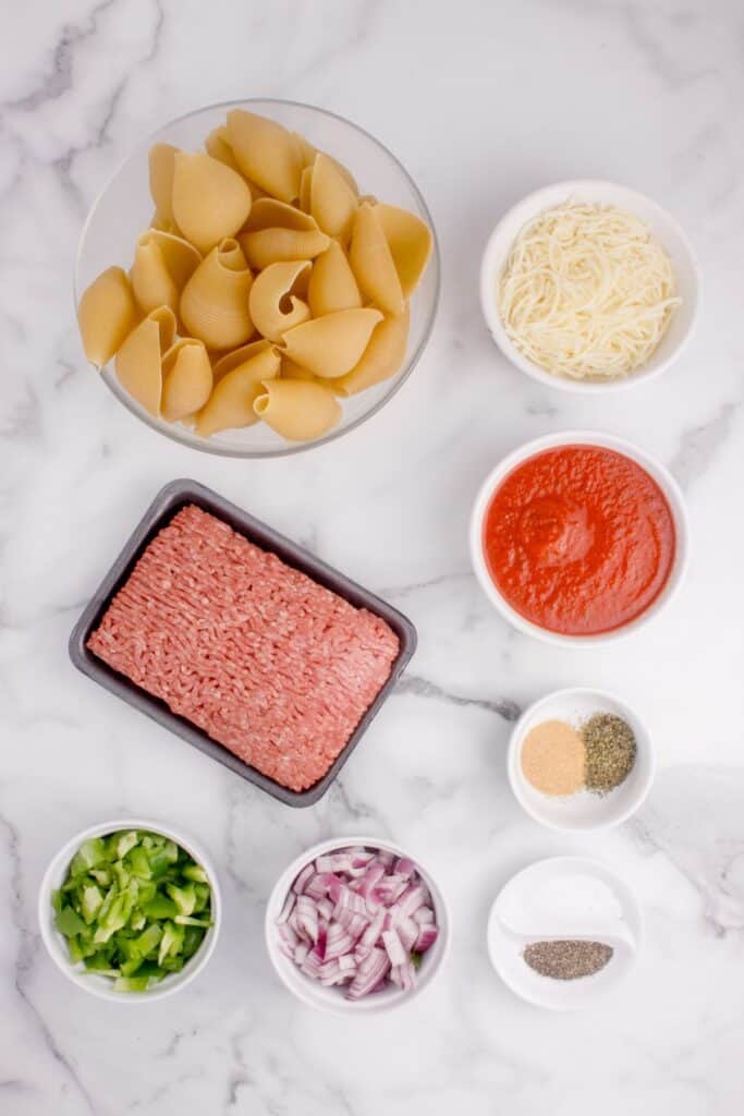 Ingredients for beef stuffed shells: Jumbo Pasta Shells, Pasta Sauce, Mozzarella, Lean Ground Beef, Onion, Bell Pepper, Italian Seasoning, Garlic Powder, Kosher Salt & Black Pepper, Fresh Herbs.