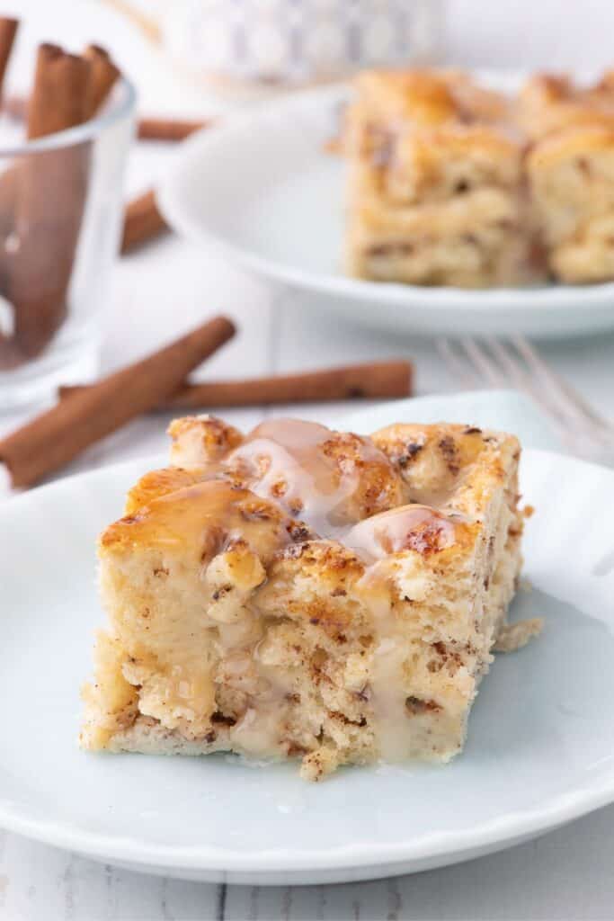 Slice of cinnamon roll casserole on a white serving plate.