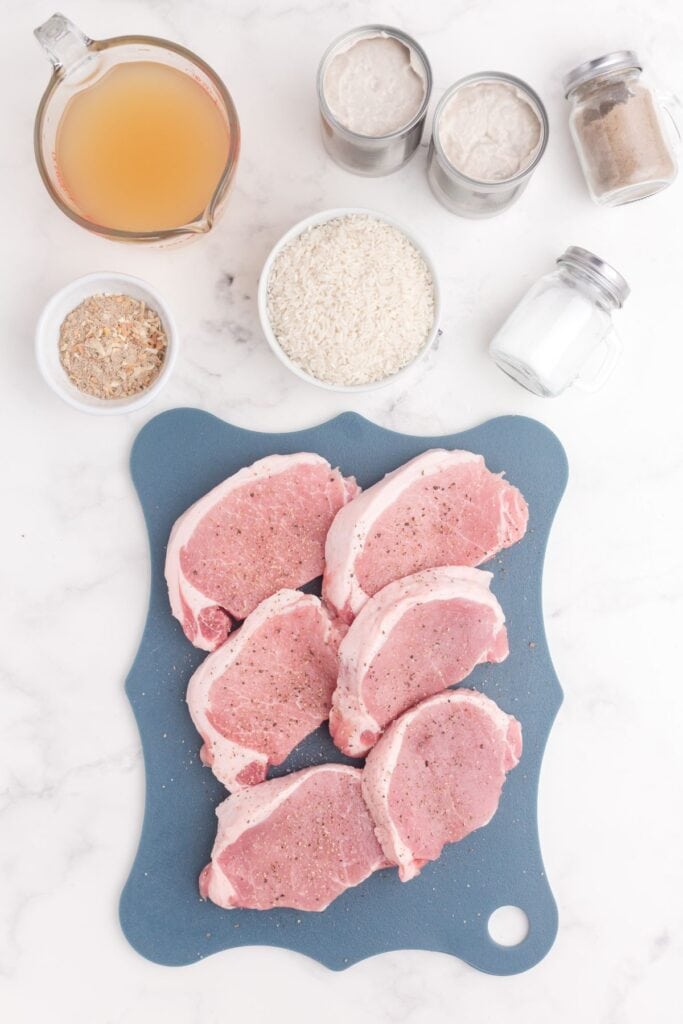 Ingredients for pork chop casserole: boneless pork chops, cream of mushroom soup, chicken broth, long grain rice, onion soup mix, salt, pepper, and parsley.