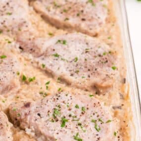 Close up view of pork chop casserole in the glass baking dish.