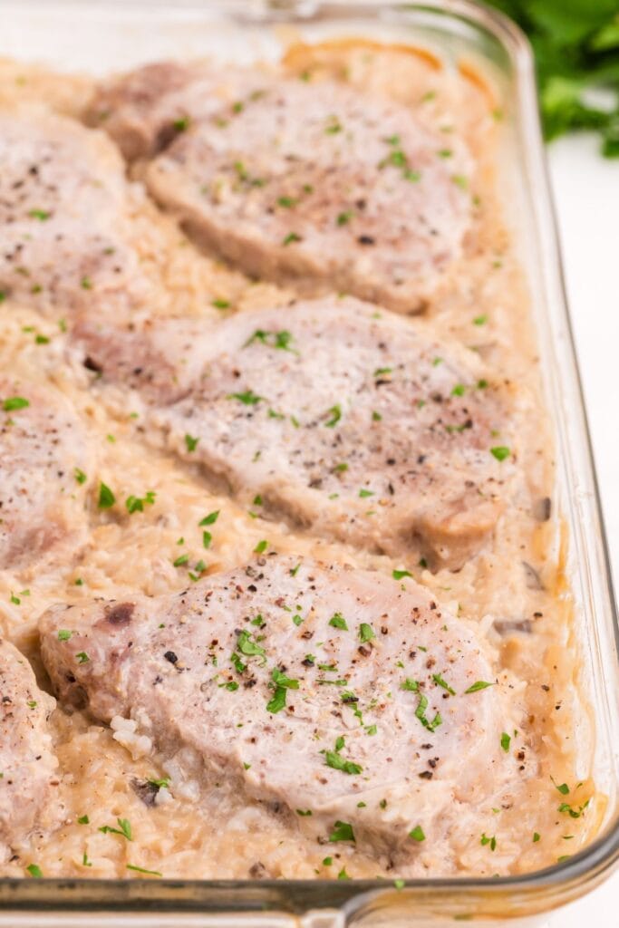 Close up view of pork chop casserole in the glass baking dish.