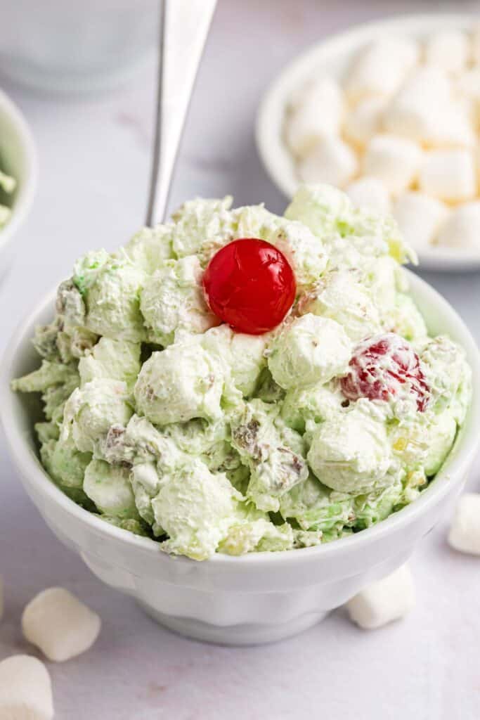 Single serving of Watergate jello salad in a bowl with a spoon.