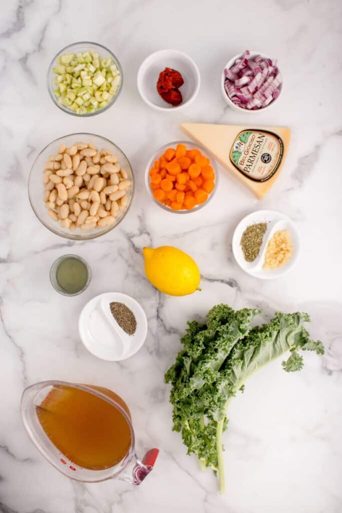 Ingredients for white bean soup: Cannellini beans, kale, chicken broth, onion, carrot, celery, garlic, extra virgin olive oil, tomato paste, parmesan, Italian seasoning, salt & pepper, lemon juice, red pepper flakes, fresh parsley