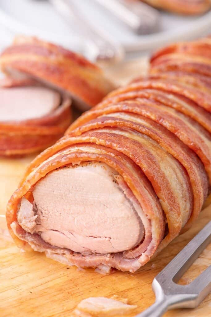 Close up of sliced bacon wrapped pork tenderloin.