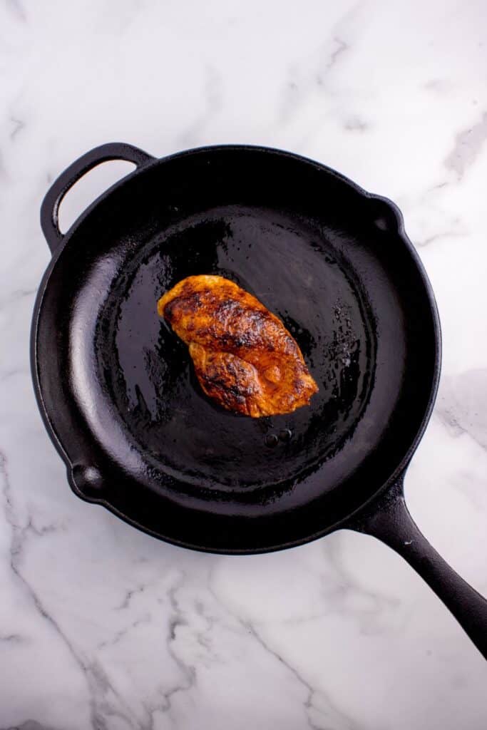 Cooked chicken in a cast iron pan.