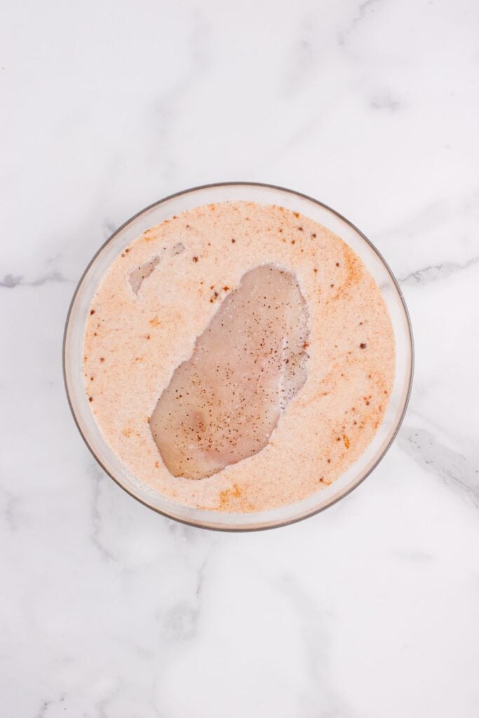 Raw chicken in a bowl of milk.