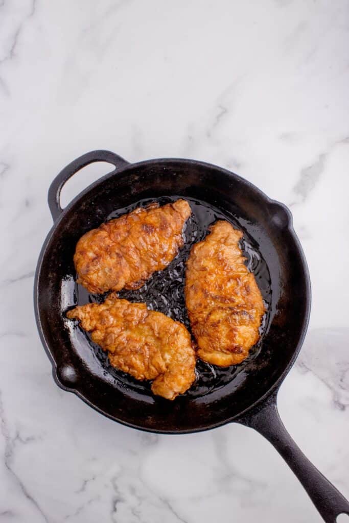 Chicken fried chicken in a cast iron pan.