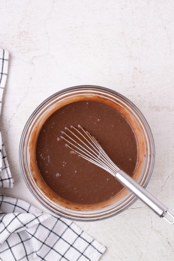 Instant pudding mix in a glass bowl with a whisk.