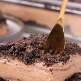 Close up of a piece of dirt cake with a gold fork.