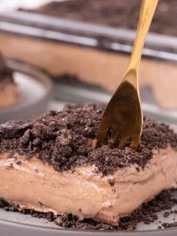 Close up of a piece of dirt cake with a gold fork.