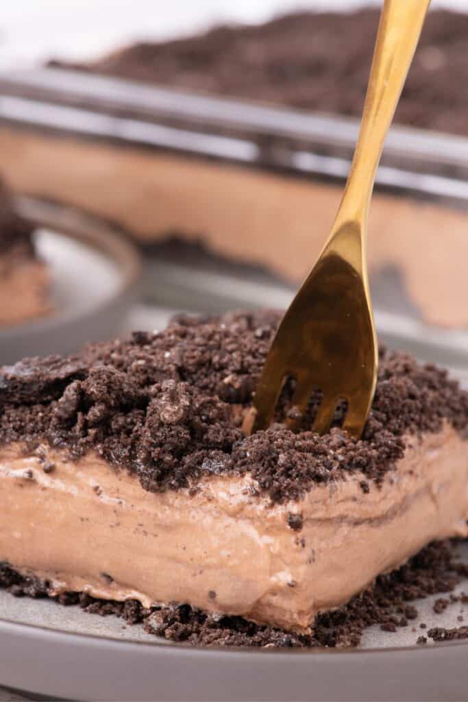 Close up of a piece of dirt cake with a gold fork.