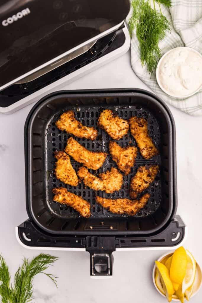 Cooked fish sticks in the air fryer basket.