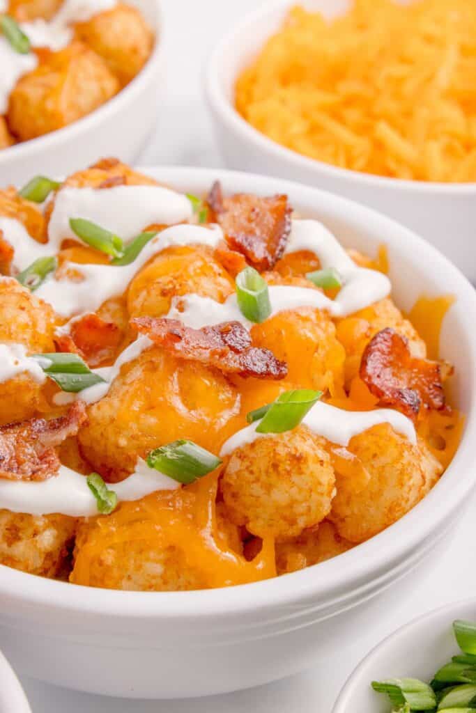 Tater tots loaded with sour cream, bacon, cheese, and green onions.