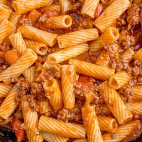 Close up of pasta bolognese in a large skillet.