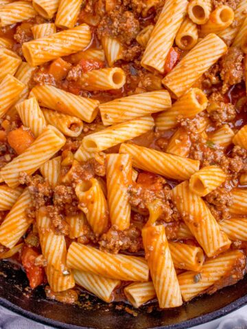 Close up of pasta bolognese in a large skillet.