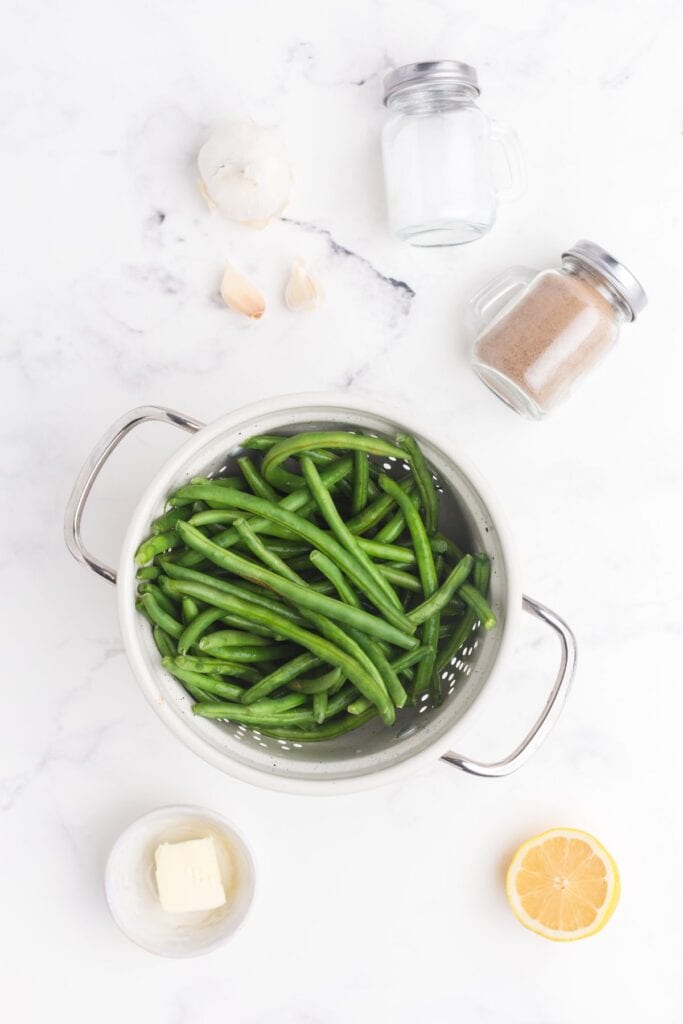 Ingredients for garlic green beans: green beans, garlic, butter, salt, pepper, and lemon.