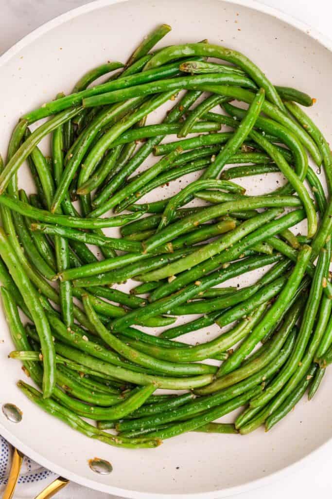 Cooked garlic green beans in a skillet.