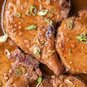 Completed honey garlic pork chops in a cast iron pan.