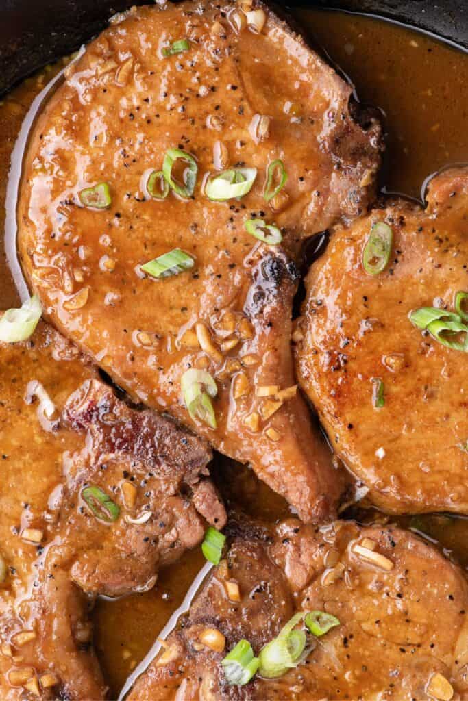 Completed honey garlic pork chops in a cast iron pan.