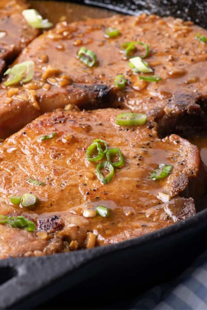 Completed pork chops in a cast iron pan.