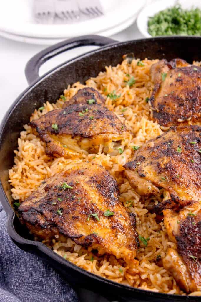 Close up of chicken and rice in a cast iron pan.